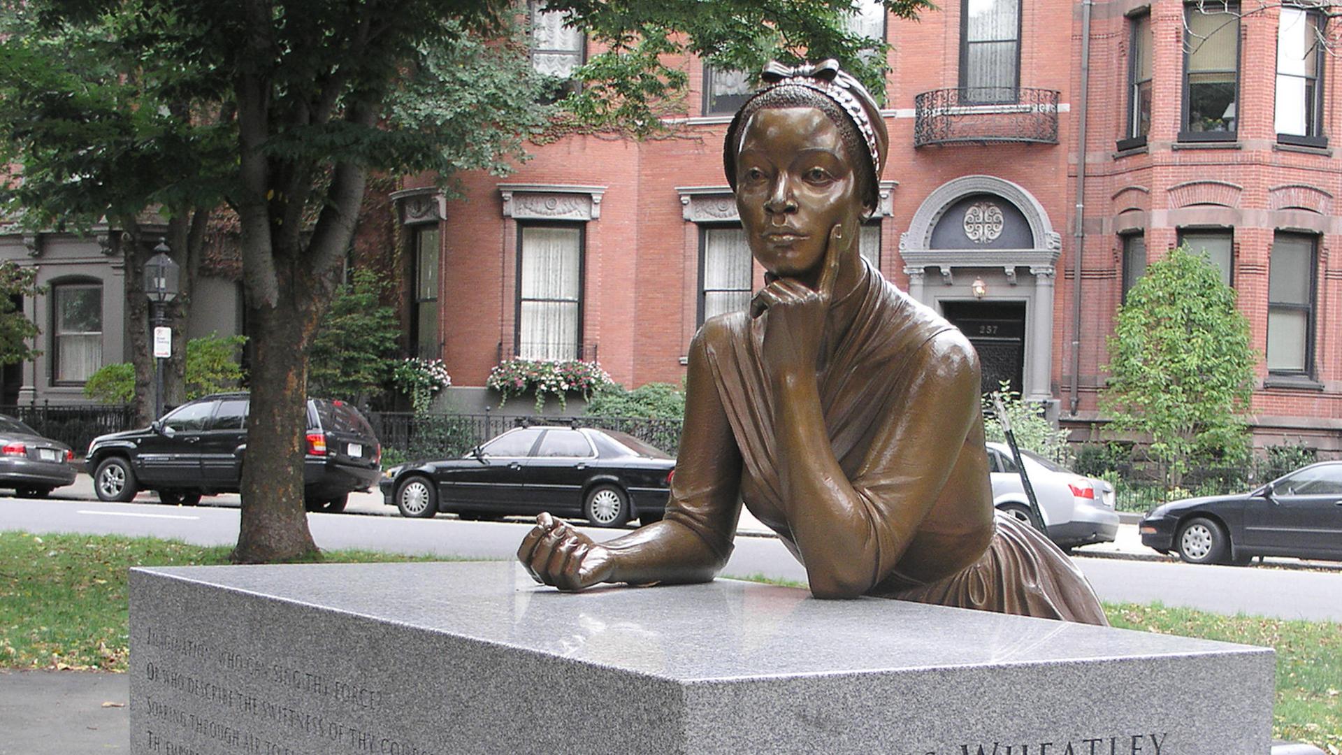 Eine Bronzeskulptur zeigt die Lyrikerin Phillis Wheatley in nachdenklicher Position.