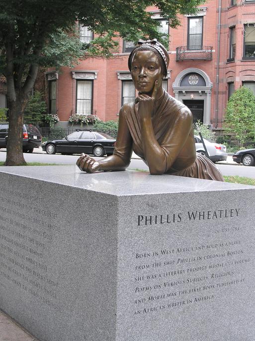 Eine Bronzeskulptur zeigt die Lyrikerin Phillis Wheatley in nachdenklicher Position.