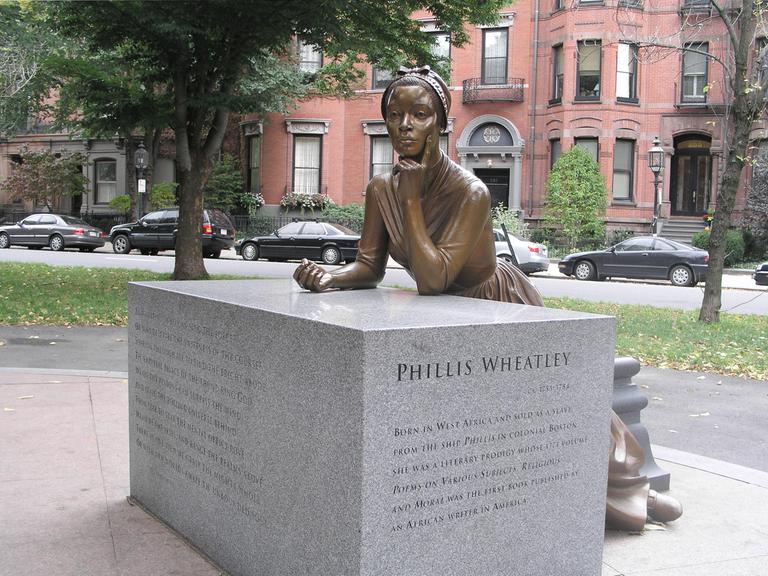 Eine Bronzeskulptur zeigt die Lyrikerin Phillis Wheatley in nachdenklicher Position.