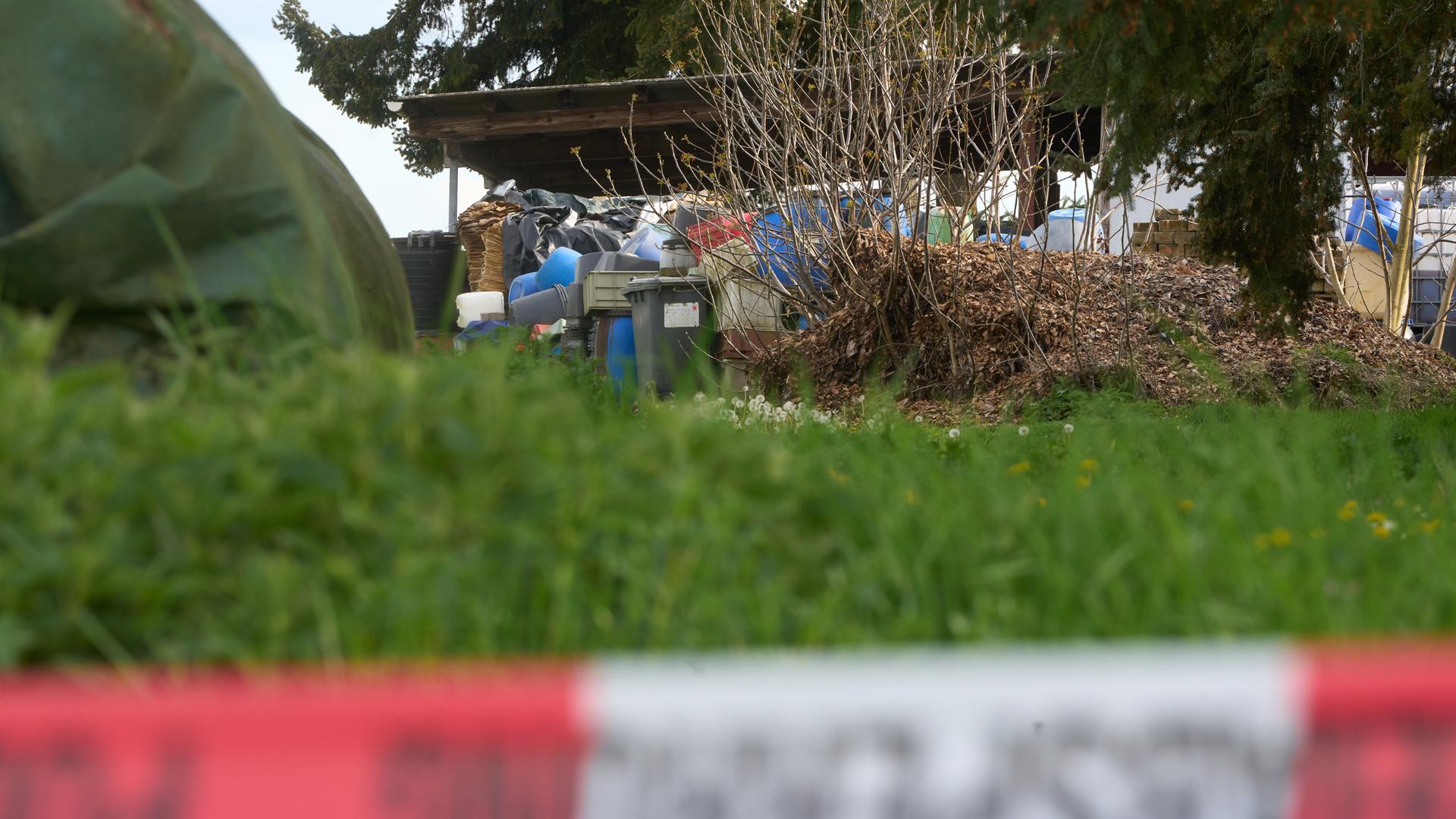 Behälter von Chemikalien sind hinter einer Polizei-Absperrung in der Nähe der Unfallstelle zu sehen. 