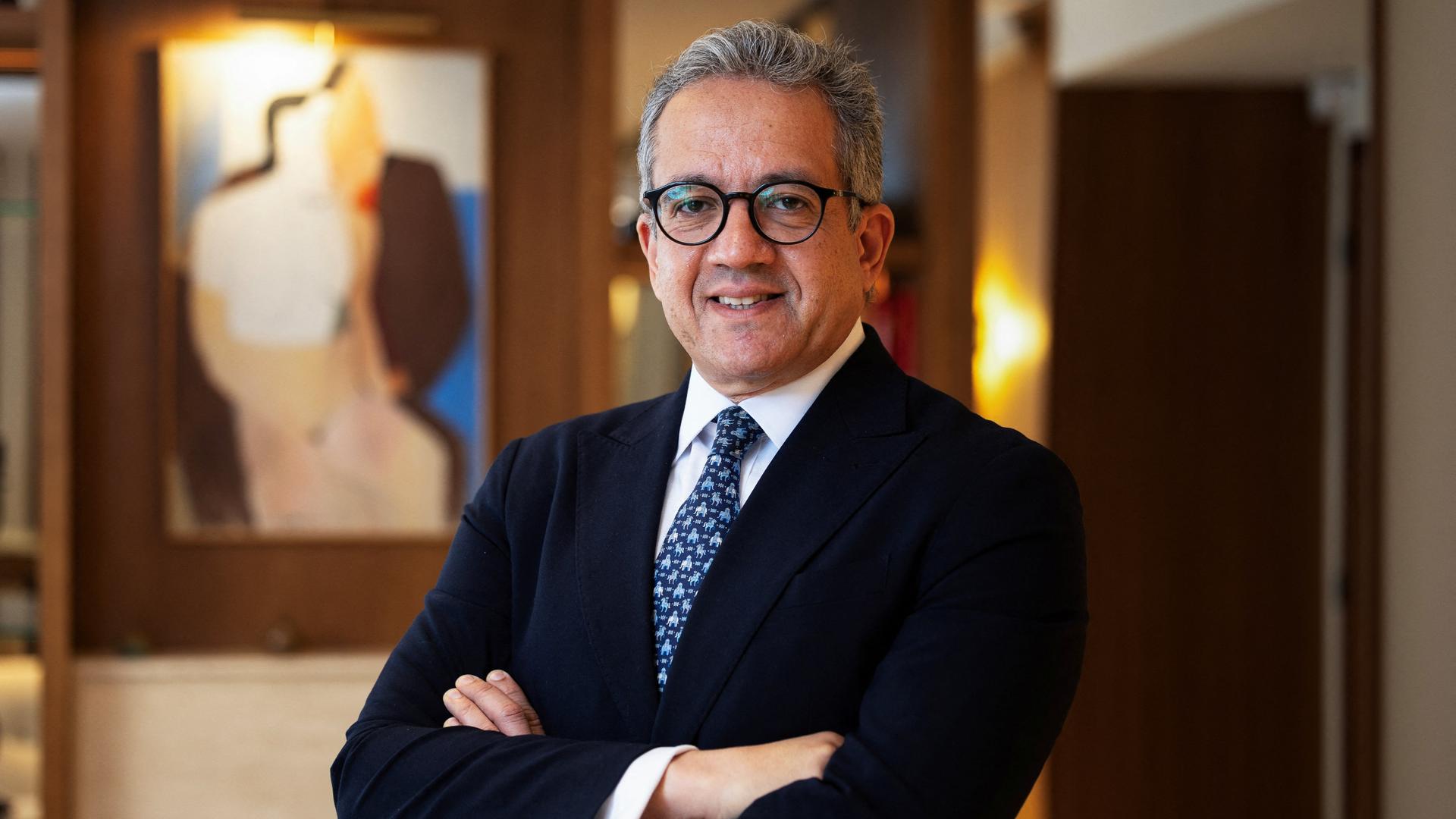 Khaled El-Enany, ehemaliger ägyptischer Tourismusminister, steht vor einem Gemälde und lächelt in die Kamera. Khaled El-Enany, ehemaliger ägyptischer Tourismusminister, steht vor einem Gemälde und lächelt in die Kamera.