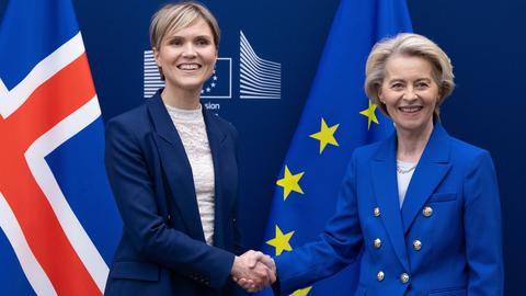 Das Foto zeigt die isländische Regierungschefin Frostadottir und EU-Kommissionspräsidentin von der Leyen. Sie geben sich die Hand und blicken Richtung Kamera.