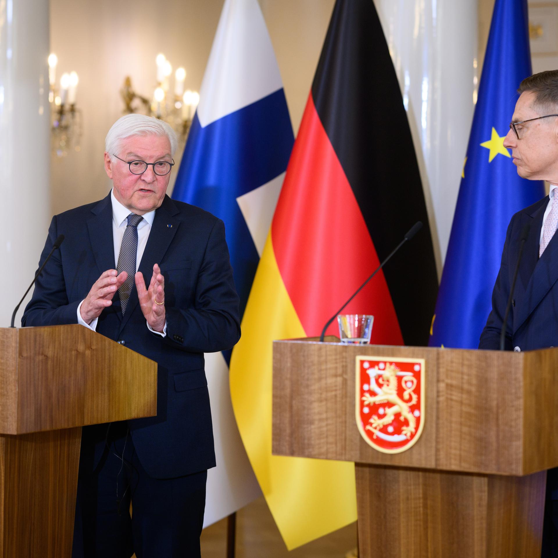 Bundespräsident Steinmeier (l) und der finnische Präsident Stubb äußern sich bei einer Pressekonferenz. Sie tragen beide einen dunklen Anzug und stehen an hölzernen Pulten mit Mikrofon. 