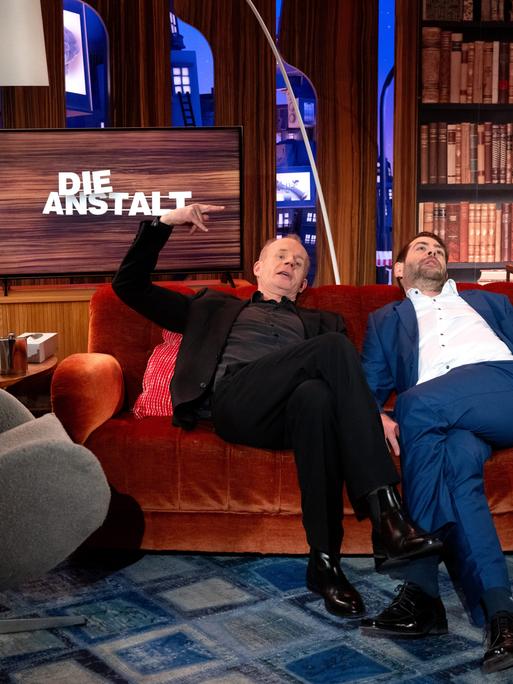 Max Uthoff und Claus von Wagner sitzen nach der Aufzeichnung einer Jubiläumssendung von der ZDF-Politsatire "Die Anstalt" in einem TV-Studio für ein Foto zusammen.