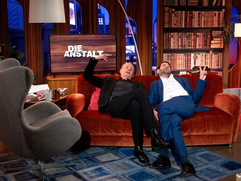Max Uthoff und Claus von Wagner sitzen nach der Aufzeichnung einer Jubiläumssendung von der ZDF-Politsatire "Die Anstalt" in einem TV-Studio für ein Foto zusammen.