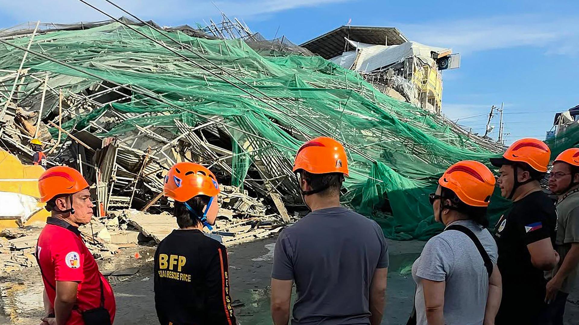 Zu sehen ist ein eingestürztes Gebäude im philippinischen Angeles City, davor stehen Rettungskräfte.