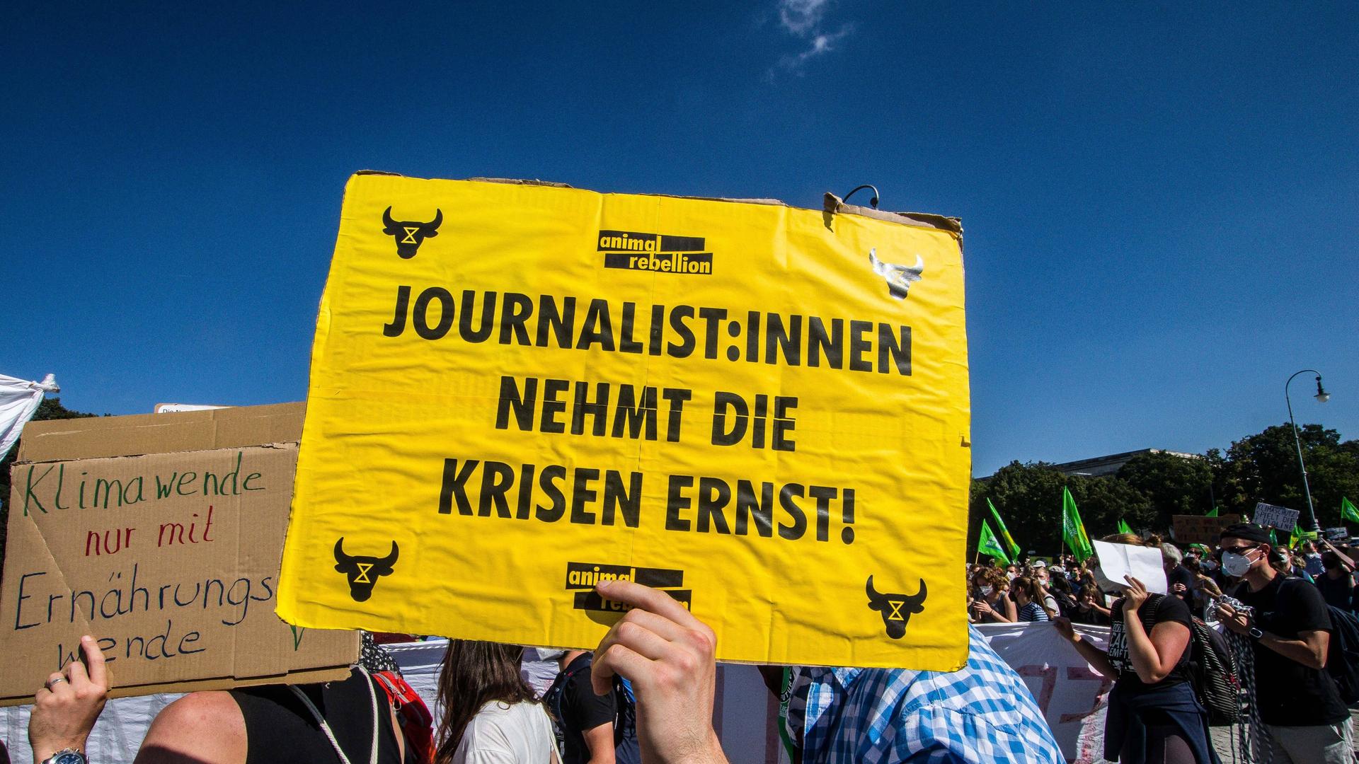 Auf einem Plakat fordert ein Demonstrierender bei der globalen Klimademo 2021 in München Journalisten mit einem Plakat dazu auf, die Klimakrise ernst zu nehmen.
