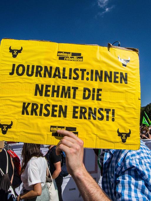 Auf einem Plakat fordert ein Demonstrierender bei der globalen Klimademo 2021 in München Journalisten mit einem Plakat dazu auf, die Klimakrise ernst zu nehmen.
