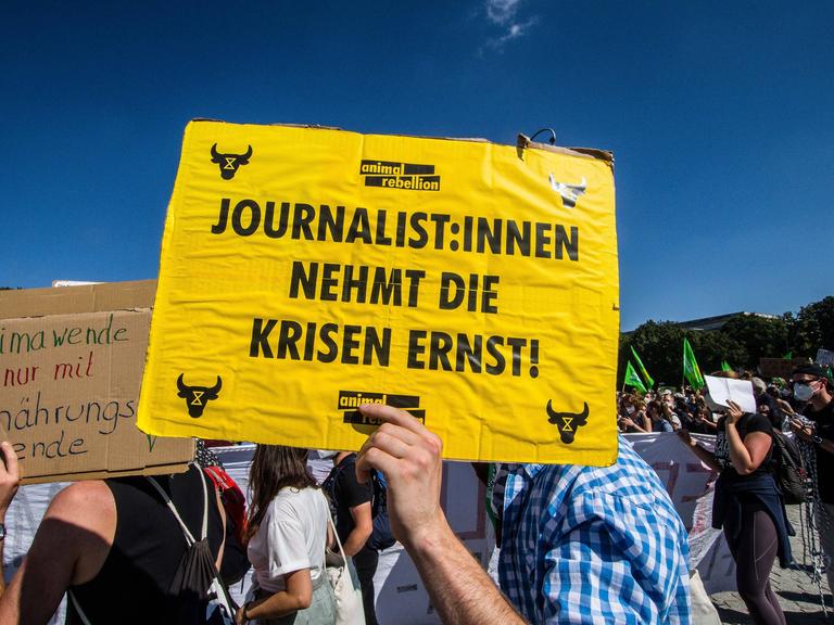 Auf einem Plakat fordert ein Demonstrierender bei der globalen Klimademo 2021 in München Journalisten mit einem Plakat dazu auf, die Klimakrise ernst zu nehmen.