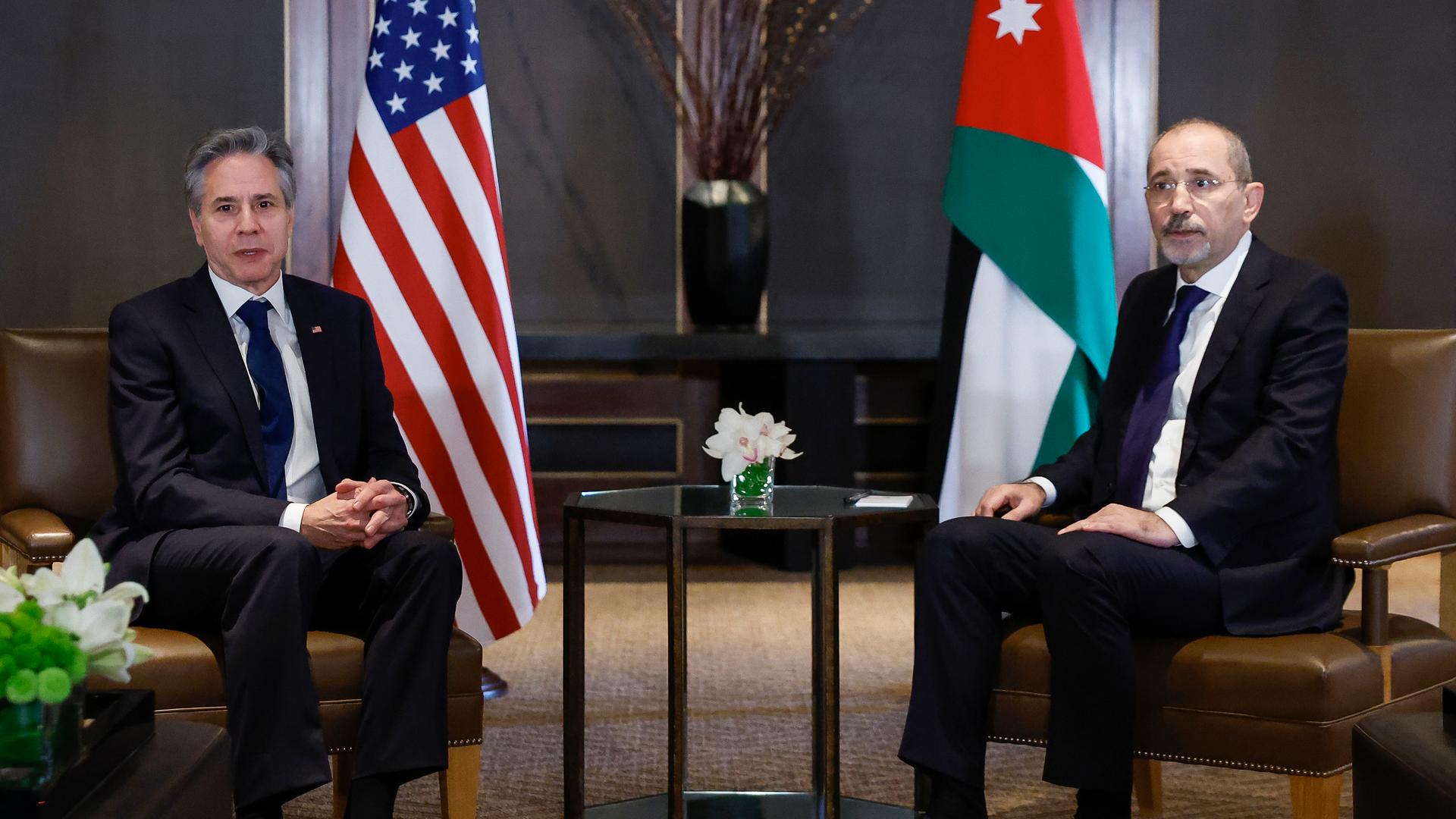 US-Außenminister Antony Blinken und sein jordanischer Amtskollegen Ayman Safadi sitzen nebeneinander auf Stühlen vor den Fahnen ihrer jeweiligen Länder. US-Außenminister Antony Blinken und sein jordanischer Amtskollegen Ayman Safadi sitzen nebeneinander auf Stühlen vor den Fahnen ihrer jeweiligen Länder.