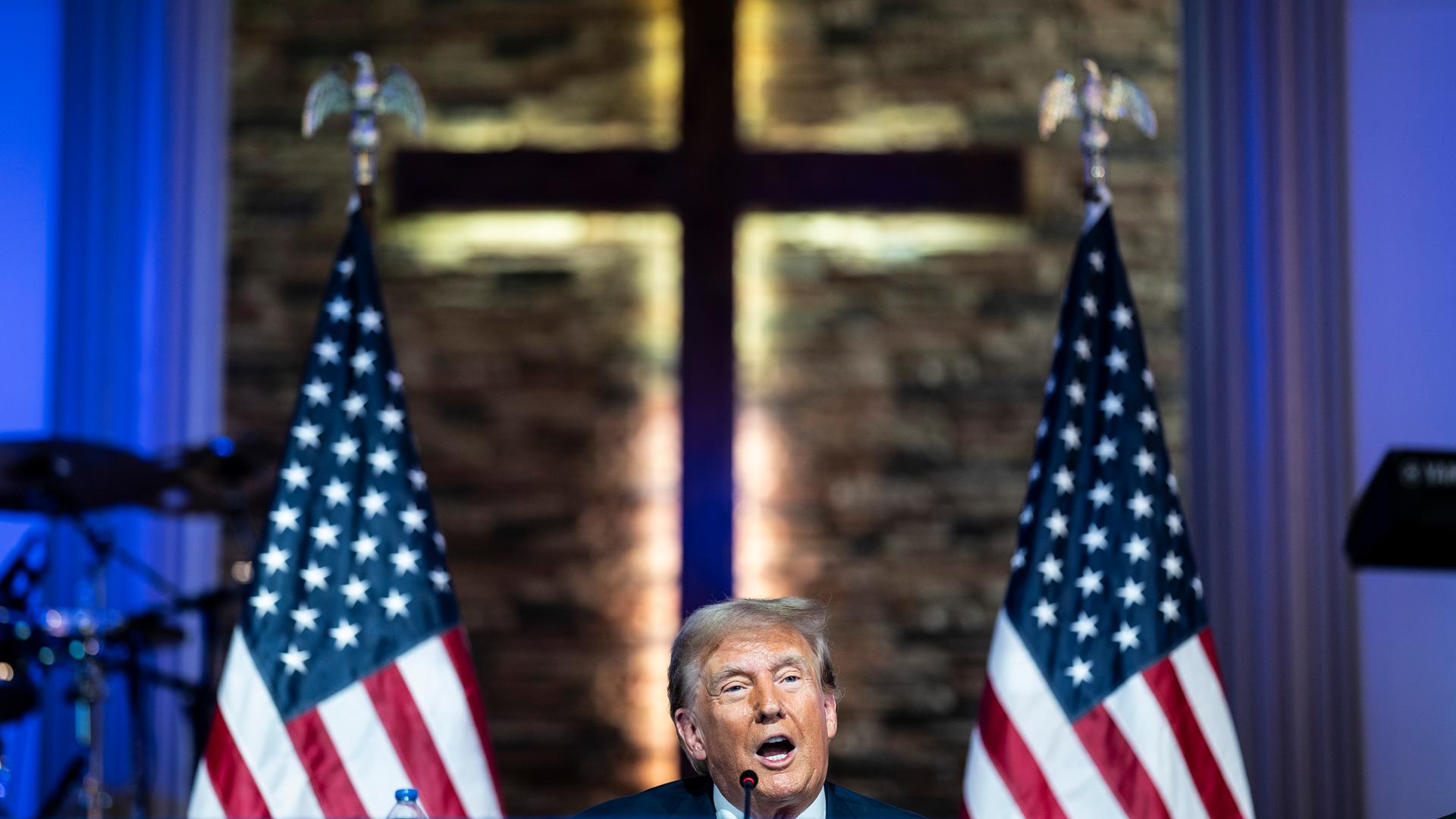 Donald Trump spricht in der Gemeinde „180 Church“ in Detroit, Michigan, vor dem Hintergrund eines Kreuzes.