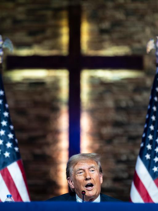 Donald Trump spricht in der Gemeinde „180 Church“ in Detroit, Michigan, vor dem Hintergrund eines Kreuzes.