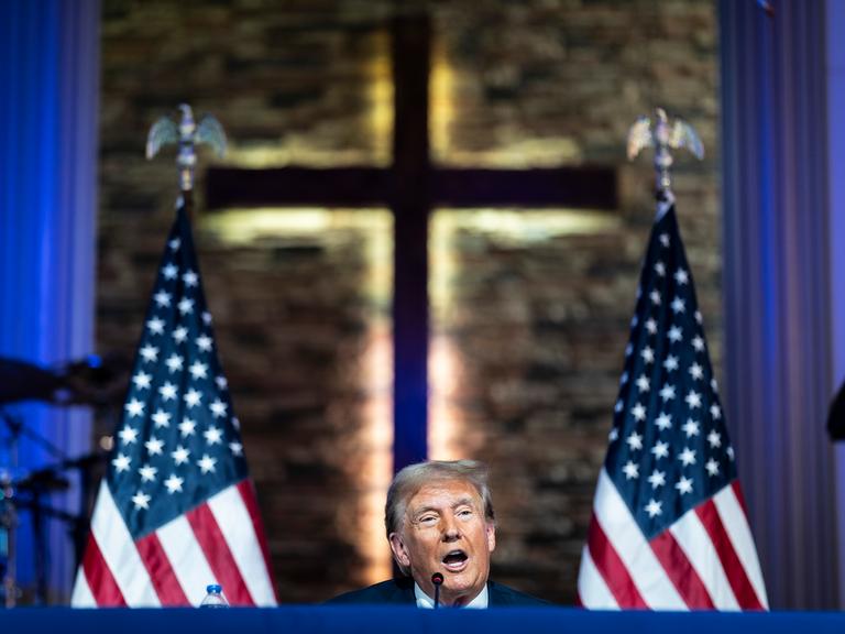 Donald Trump spricht in der Gemeinde „180 Church“ in Detroit, Michigan, vor dem Hintergrund eines Kreuzes.