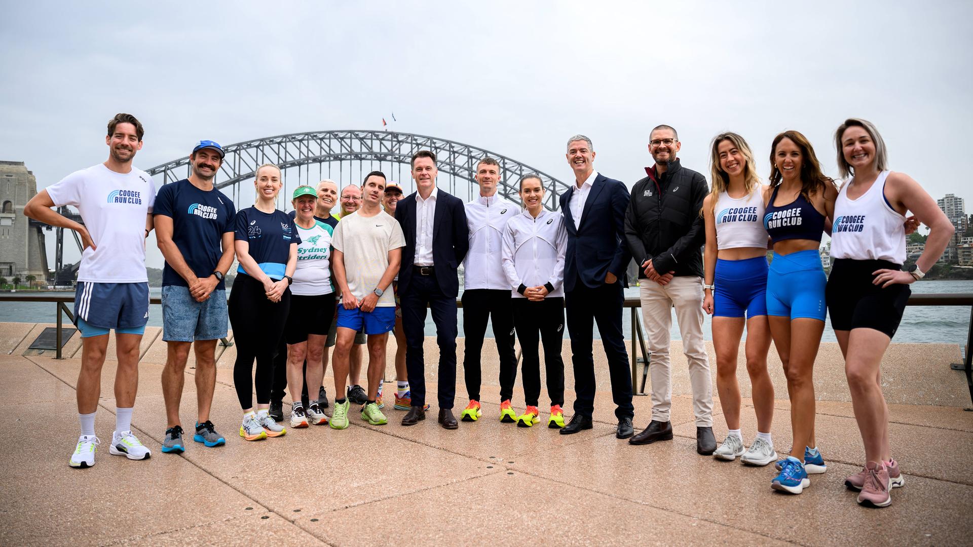 Der australische Premier Minns und der Tourismusminister Graham posieren mit Marathonläufern.