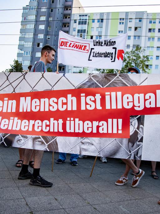 Zwei Menschen halten einen Banner mit der Aufschrift "Kein Mensch ist illegal".