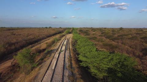 Blick auf eine Bahnstrecke, die am Horizont im Sand plötzlich aufhört