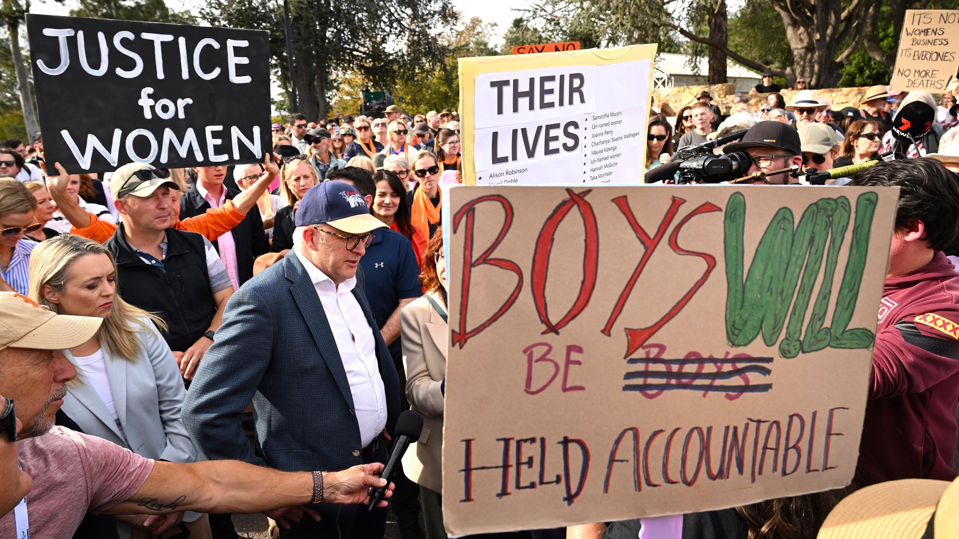 Der australische Premierminister Anthony Albanese nimmt an einer Demonstation gegen Gewalt an Frauen teil. Um ihn herum sind viele Menschen mit Plakaten. 