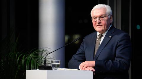 Bundespräsident Frank-Walter Steinmeier steht an einem Rednerpult mit Mikrofon, vor ihm ein Glas Wasser. Er trägt einen blauen Anzug.