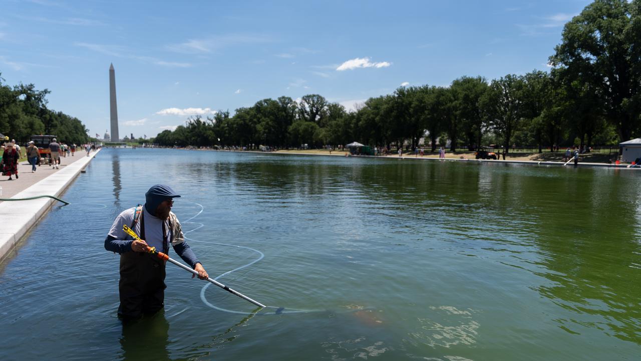 Ein Mensch steht in Washington in einem Wasserbecken und benutzt ein Reinigungsgerät.