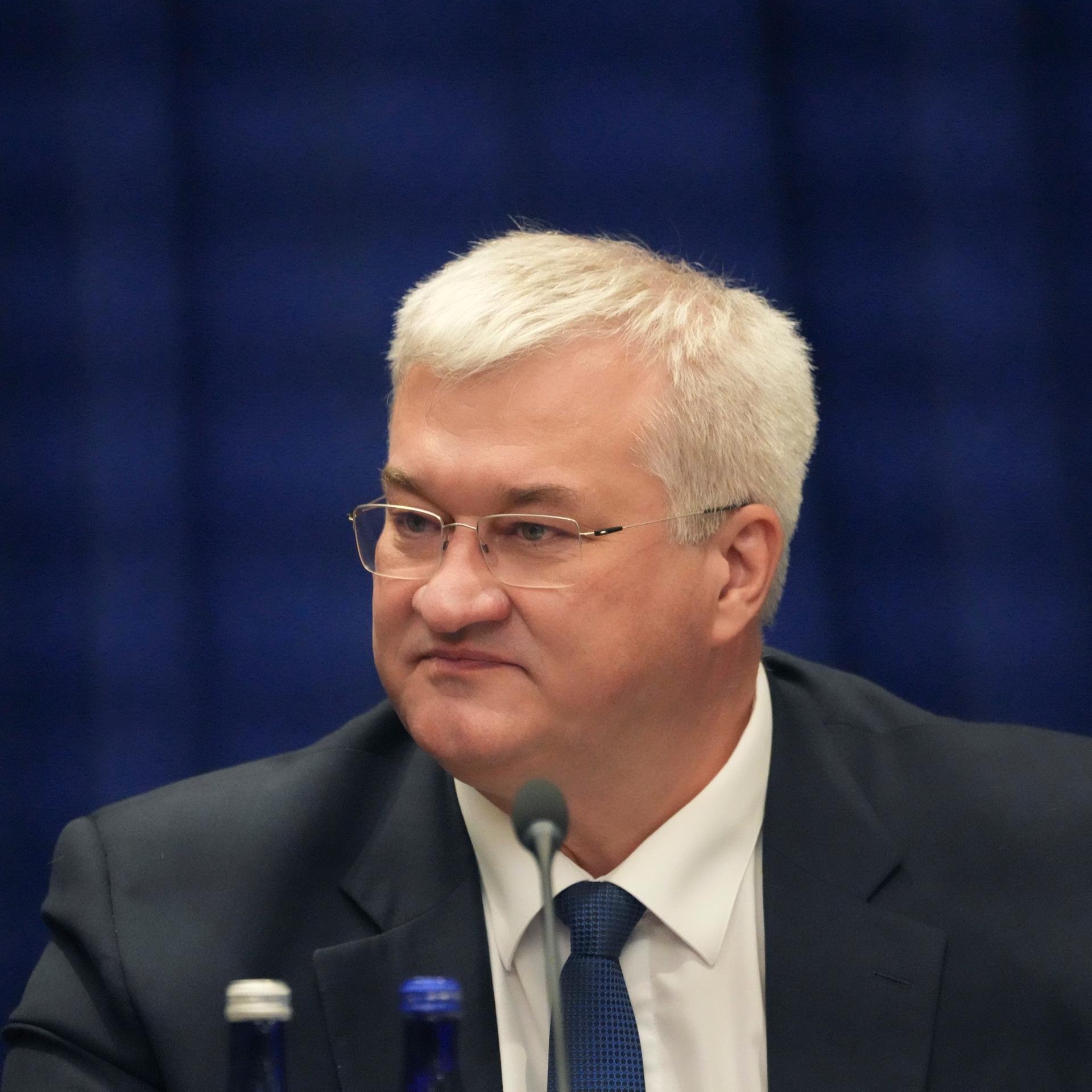 Der ukrainische Außenminister Andrij Sybiha sitzt vor Mikrofonen.