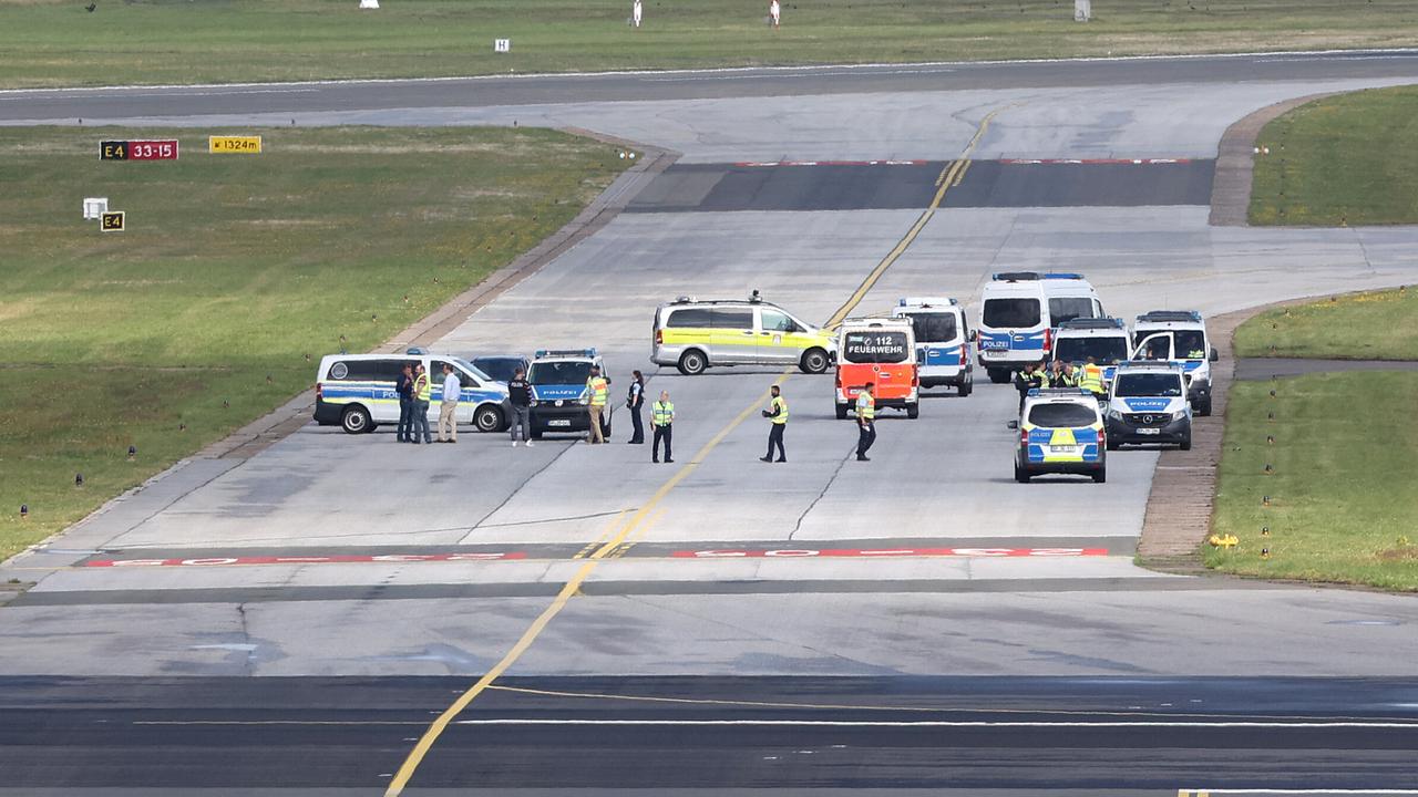 Einsatzkräfte der Polizei stehen auf einem Rollfeld des Hamburger Flughafens. Eine Gruppe von Klimaaktivisten der Letzten Generation sind bei einer Aktion auf das Rollfeld des Hamburger Flughafens gelangt und haben sich an zwei Orten festgeklebt.