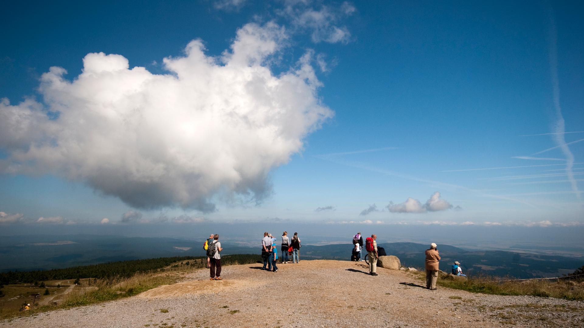 Menschen, die auf den Brocken im Harz gewandert sind, sie blicken über die Wälder und Landschaften des Harzes (Symbolbild)