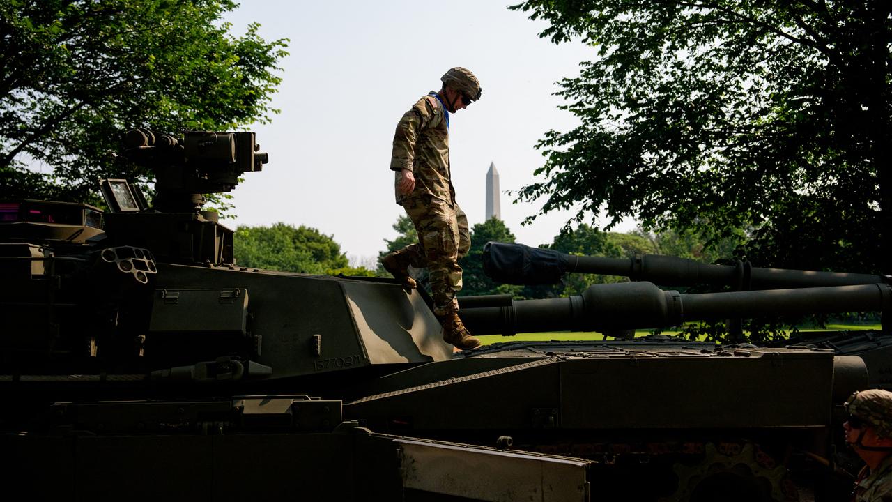 M1 Alpha a3, Abrams Panzer, Stryker und M2 Bradley: Ein US-Soldat steigt über Kampffahrzeuge. Im Hintergrund ist das Washington Monument zu sehen