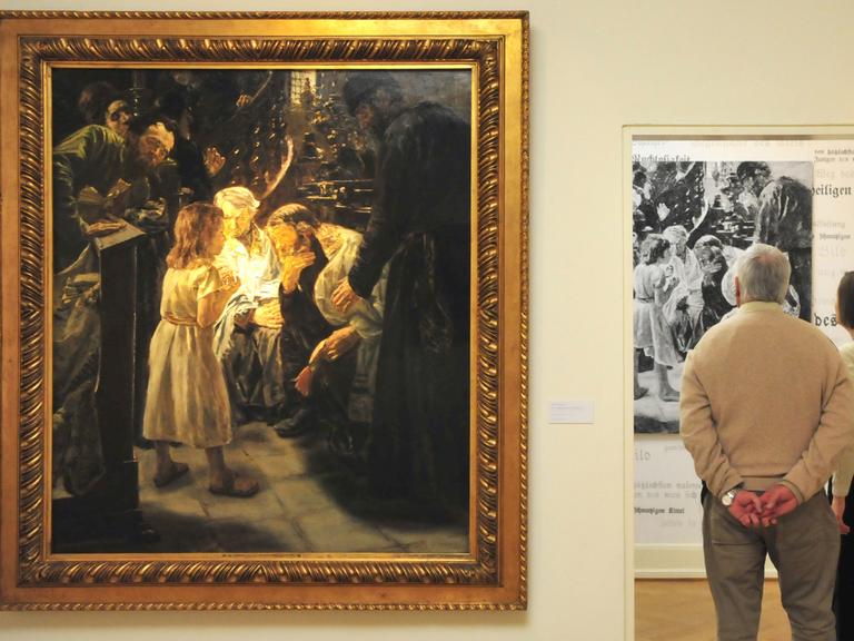 An der Wand links hängt "Der zwölfjährige Jesus im Tempel" von Max Liebermann. Rechts stehen Besucher der Ausstellung, die dem Betrachter den Rücken zuwenden. An der Wand links hängt "Der zwölfjährige Jesus im Tempel" von Max Liebermann. Rechts stehen Besucher der Ausstellung, die dem Betrachter den Rücken zuwenden.