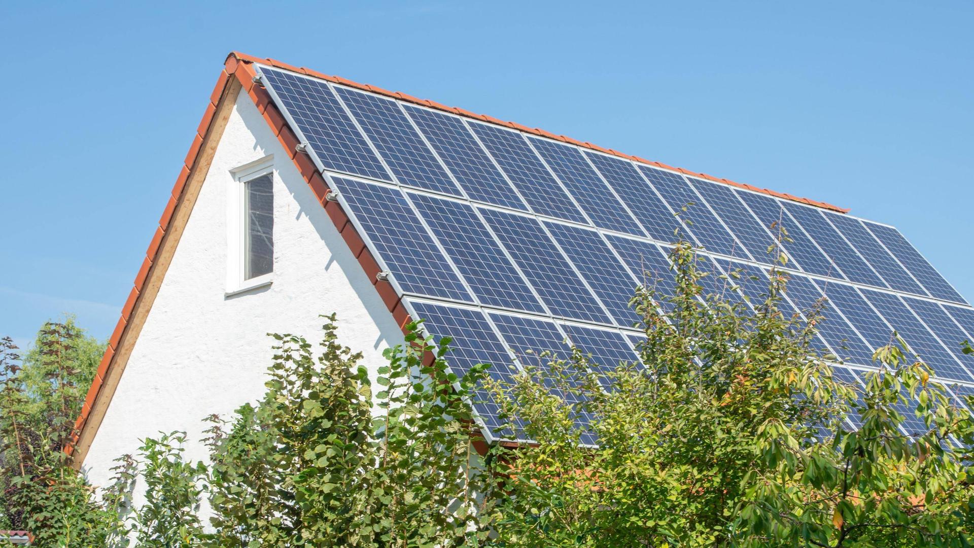 Das Dach eines Einfamilienhauses ist mit Solarzellen bebaut.