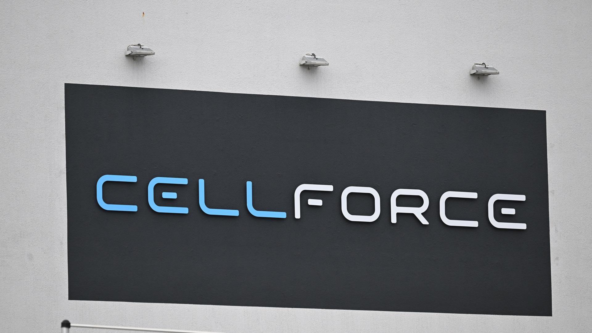 Das Logo von Cellforce: Weiß-blaue Schrift auf einem schwarzen Schild, das an einer grauen Wand hängt. Das Logo von Cellforce: Weiß-blaue Schrift auf einem schwarzen Schild, das an einer grauen Wand hängt.