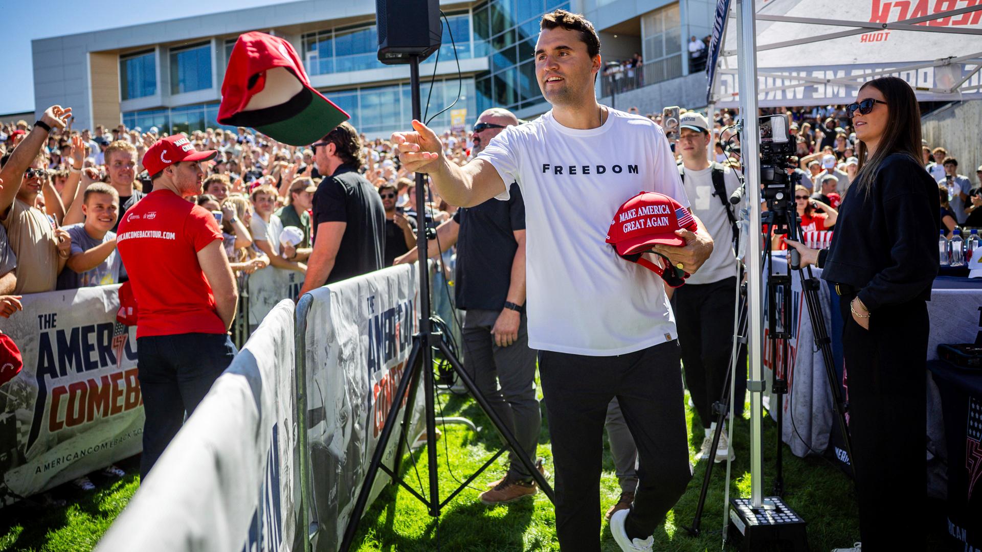 Charlie Kirk verteilt vor seiner Rede an der Utah Valley University Mützen. 