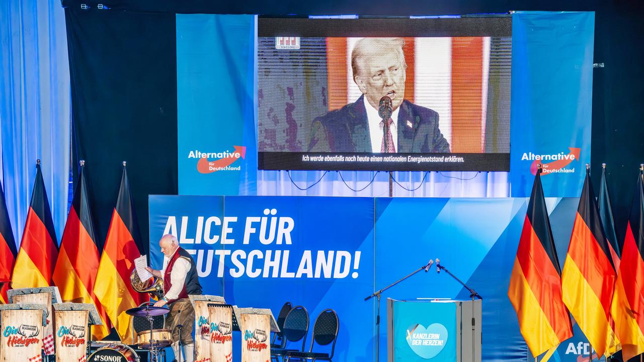 Über der Bühne bei einer Wahlkampfveranstaltung mit Deutschlandflaggen und AfD-Logos ist eine Leinwand mit einem Wahlkampfvideo von Donald Trump zu sehen Über der Bühne bei einer Wahlkampfveranstaltung mit Deutschlandflaggen und AfD-Logos ist eine Leinwand mit einem Wahlkampfvideo von Donald Trump zu sehen