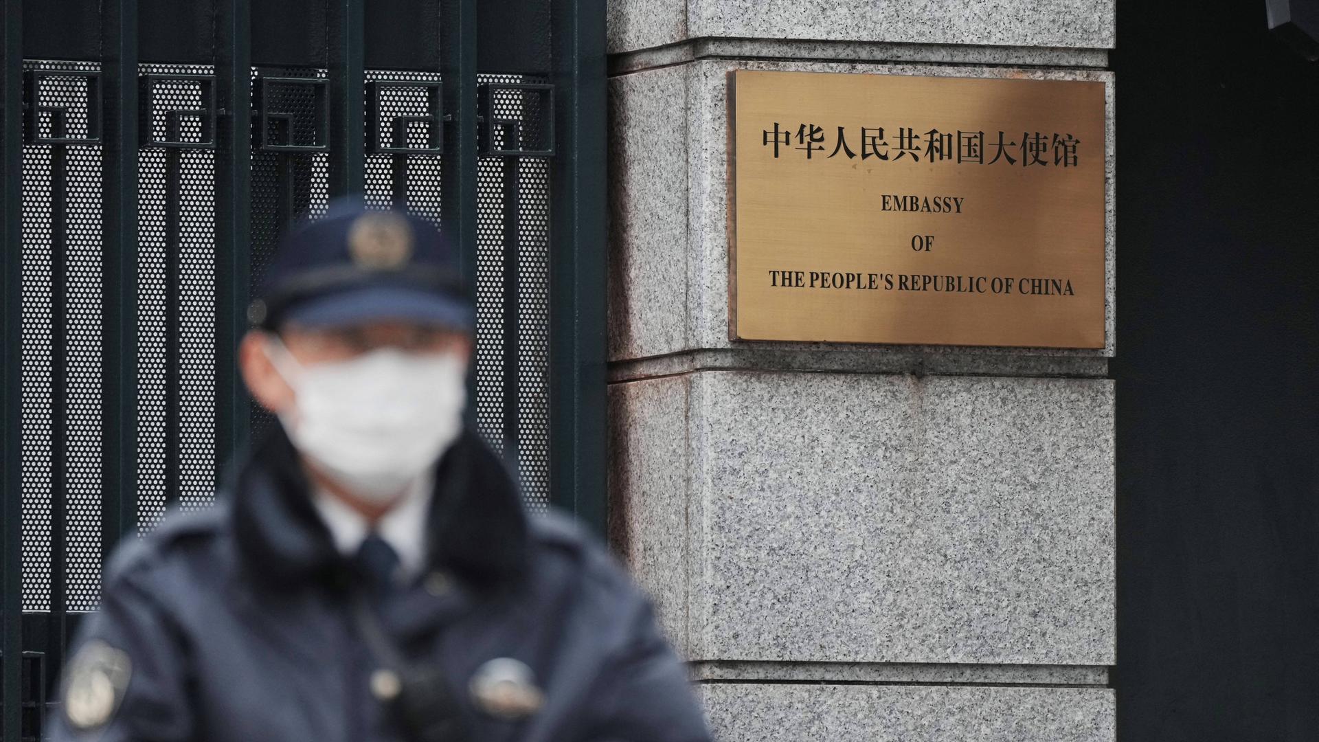 Ein Polizist mit Maske steht vor der chinesischen Botschaft in Tokio.