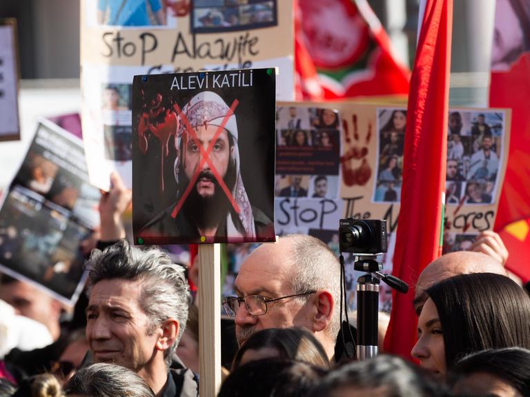 Menschen nehmen am 15. März 2025 an einer großen Demonstration gegen Tötung und Gewalt gegen die alawitische Minderheit in Syrien in Köln teil
