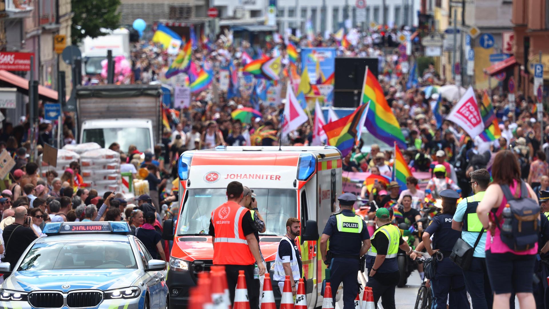 Teilnehmer des Christopher Street Day 2025 ziehen durch die Münchner Innenstadt. Vorne ist jeweils ein Einsatzwagen von Polizei und Rettungsdiensten zu sehen. Teilnehmer des Christopher Street Day 2025 ziehen durch die Münchner Innenstadt. Vorne ist jeweils ein Einsatzwagen von Polizei und Rettungsdiensten zu sehen.