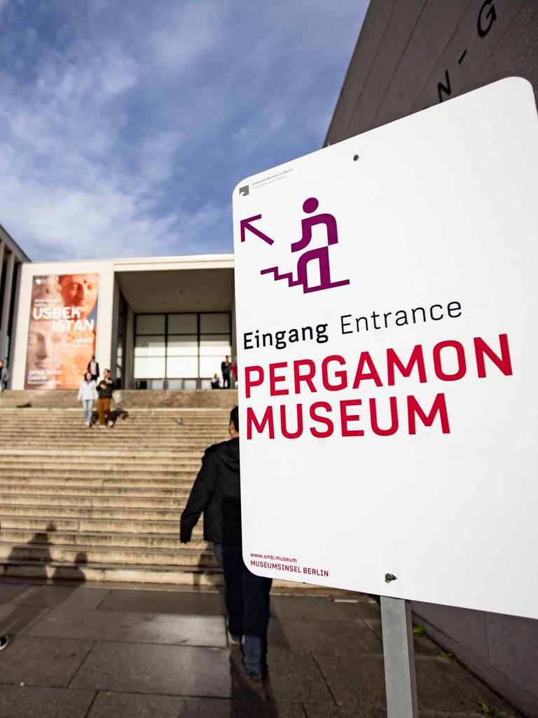 Menschen gehen die Treppe zur James Simon Galerie auf der Berliner Museumsinsel hinauf. Auf einem Schild rechts steht: Eingang Pergamonmuseum. 