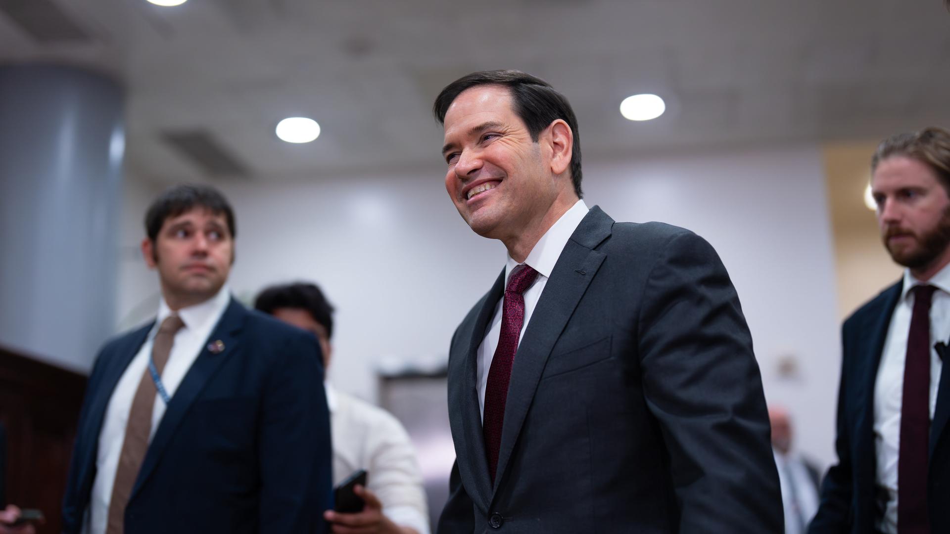 US-Außenminister Marco Rubio wird von zwei Personen begleitet. 