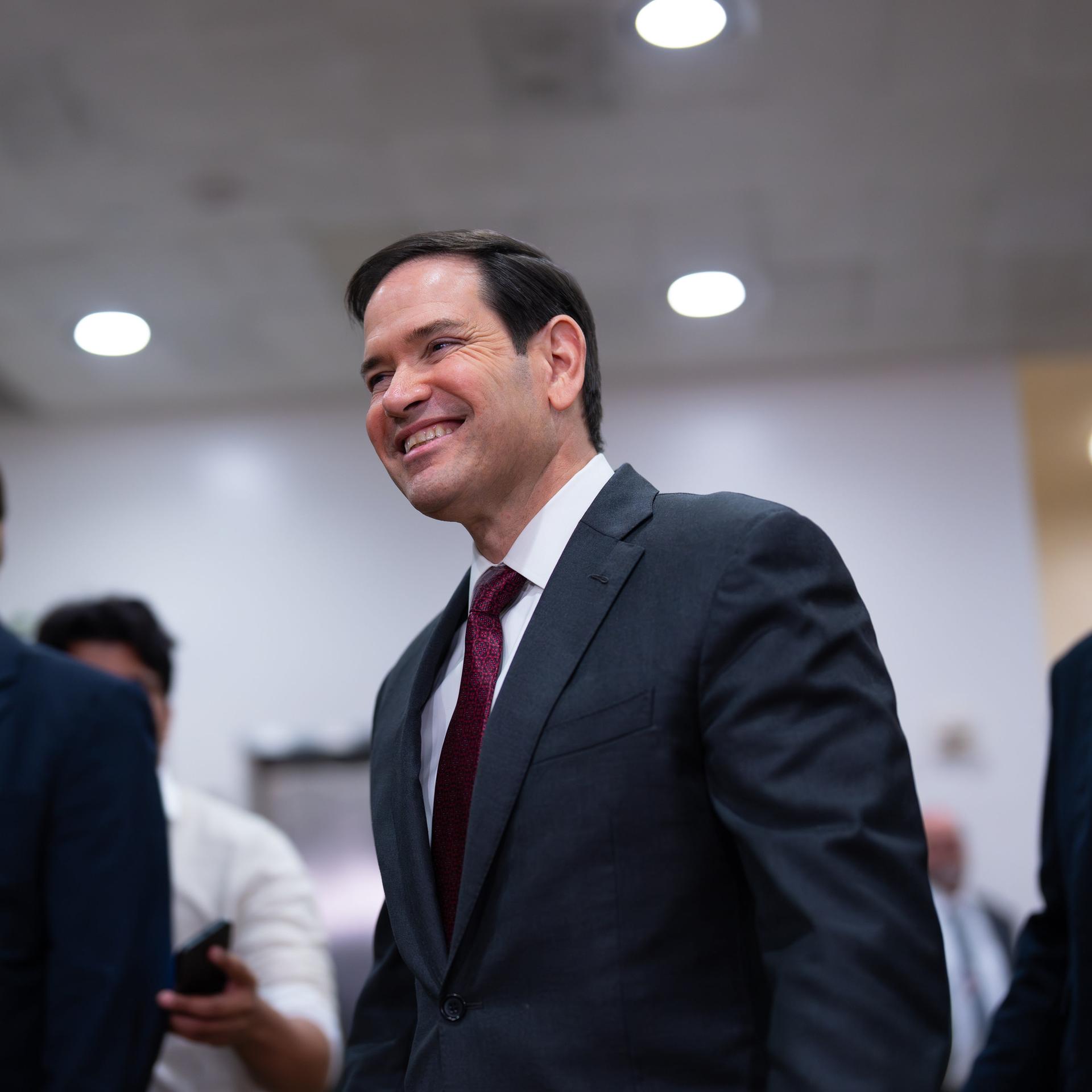 US-Außenminister Marco Rubio wird von zwei Personen begleitet. 