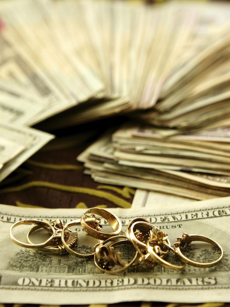 Dollarnoten und goldene Ringe auf Tischtuch