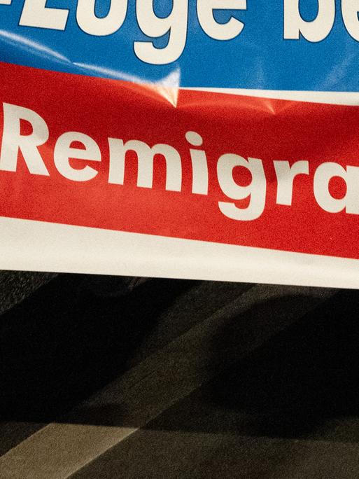 Einem Protestbanner ist das Wort "Remigration" zu lesen.