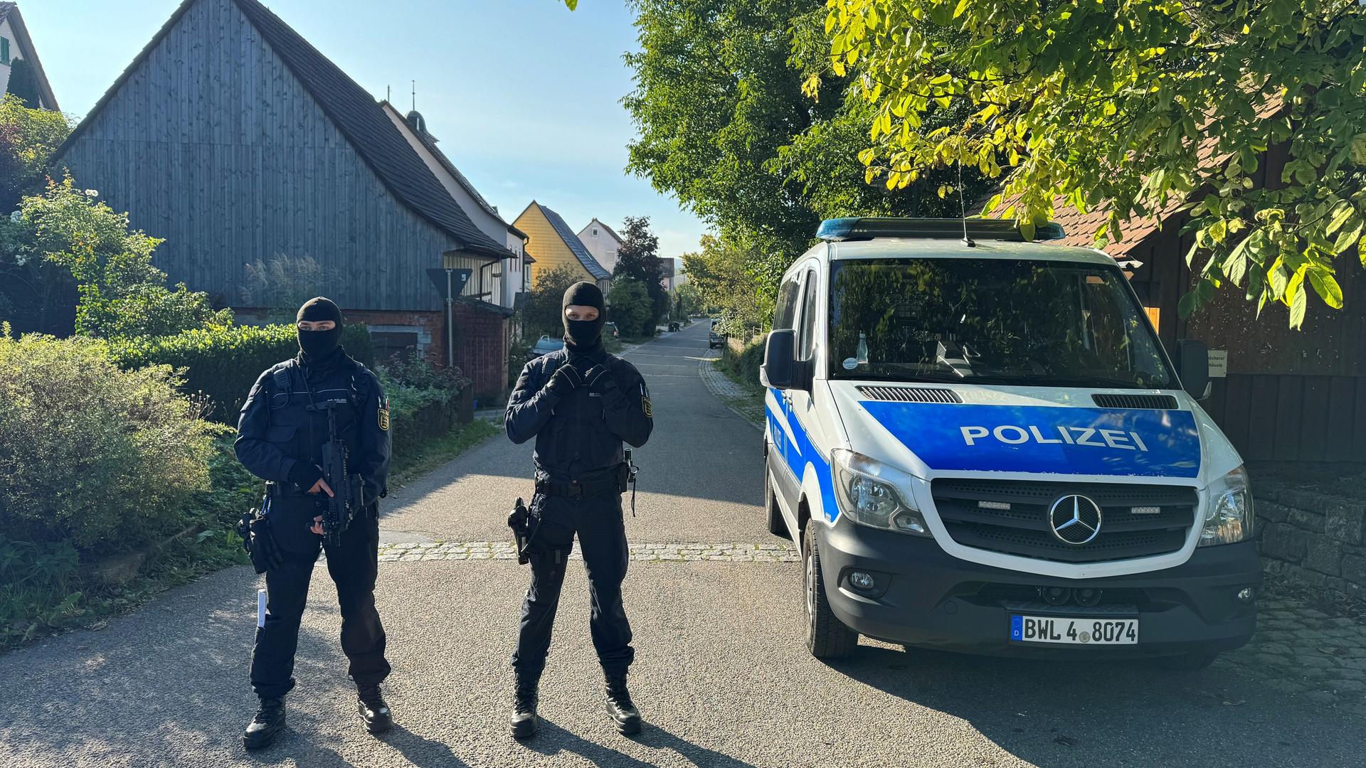 Baden-Württemberg, Kupferzell: Polizisten sichern eine Durchsuchung ab.