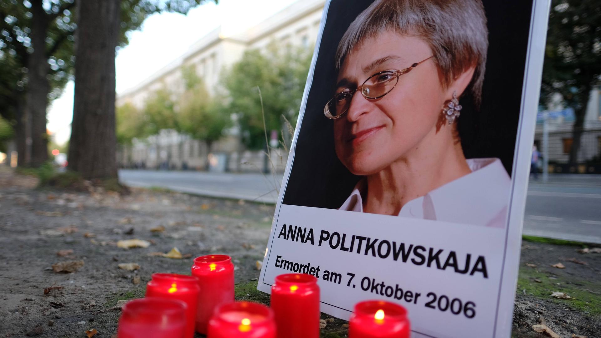 Amnesty International und Reporter ohne Grenzen erinnern am 7. Oktober mit einer Mahnwache vor der Russischen Botschaft an die ermordete Journalistin Anna Politkowskaja. Vor einem Foto von ihr brennen Kerzen.