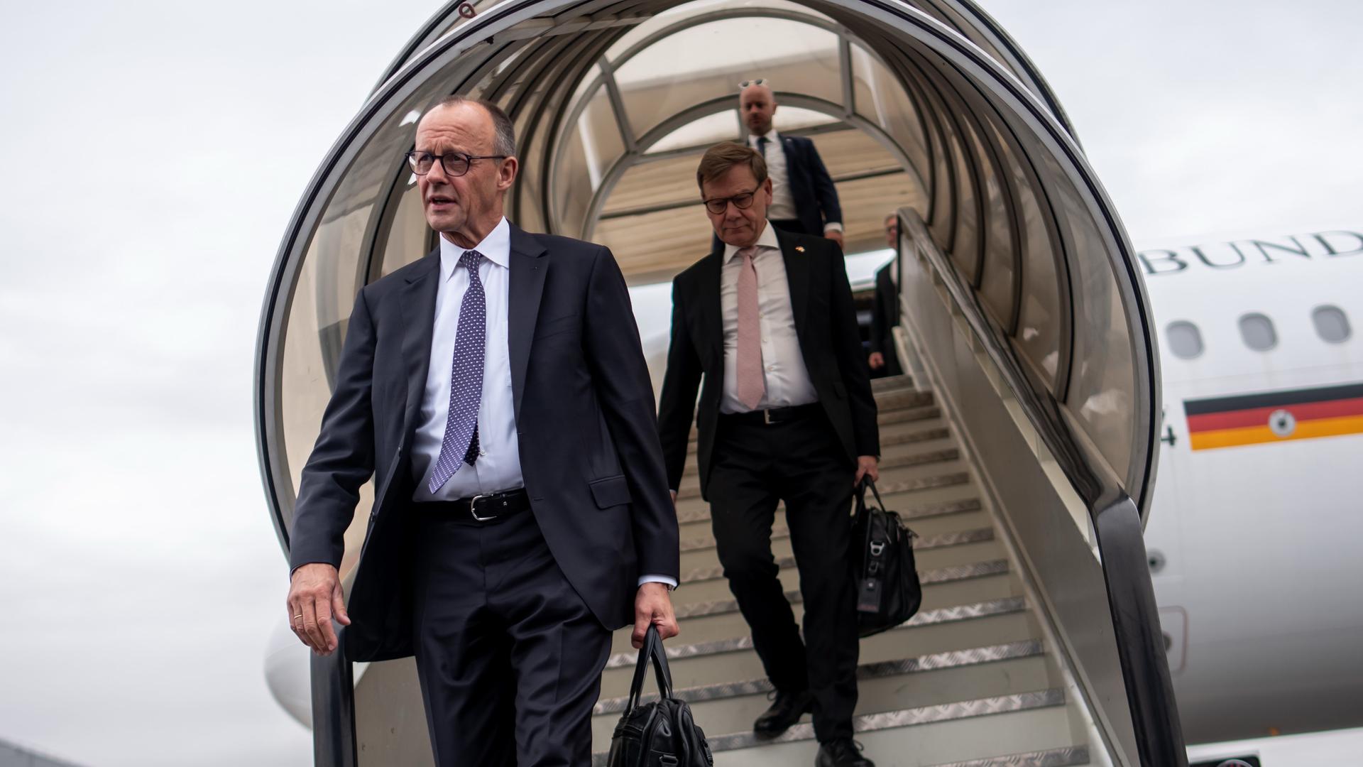 Bundeskanzler Friedrich Merz (CDU, l) steigt am Flughafen in London vor Johann Wadephul (CDU), Außenminister, aus einem Flugzeug der Flugbereitschaft. 