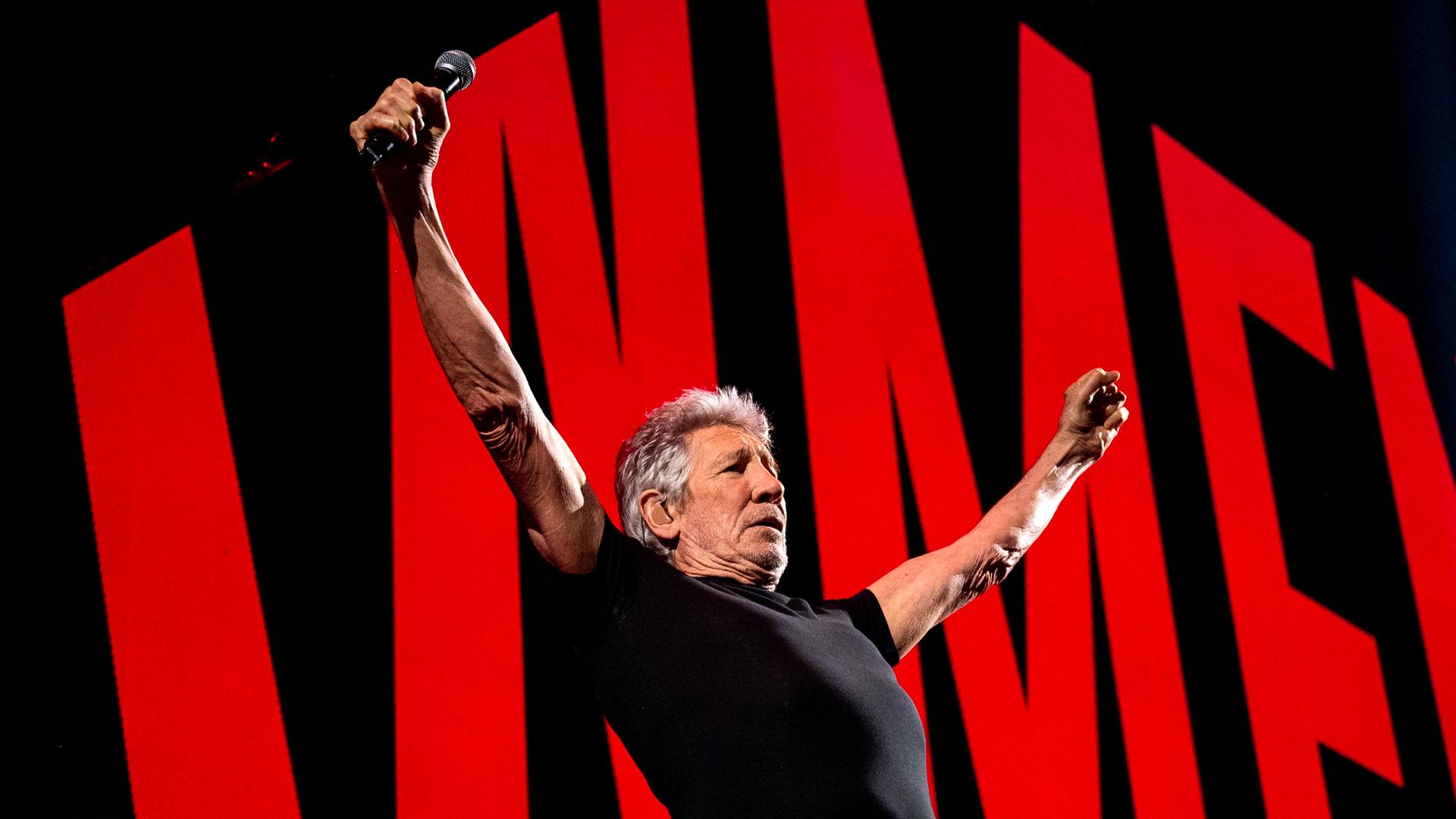 Roger Waters steht mit erhobenen Armen auf der Bühne in Hamburg