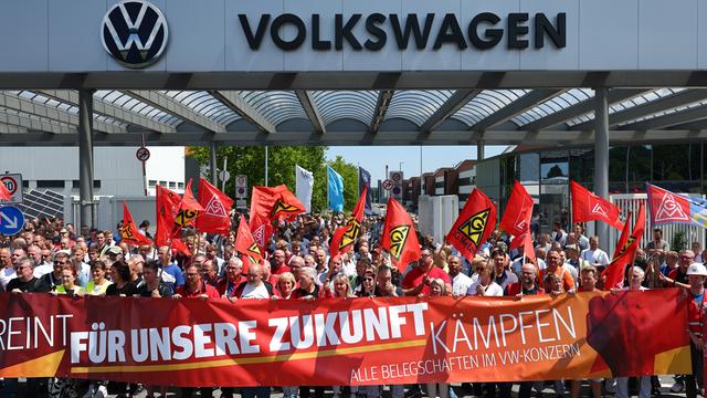 Beschäftigte von Volkswagen beteiligen sich an einer Protestaktion der IG Metall vor dem VW-Werk in Zwickau. Sie stehen hinter einem Transparent mit der Aufschrift: "Für unsere Zukunft kämpfen".