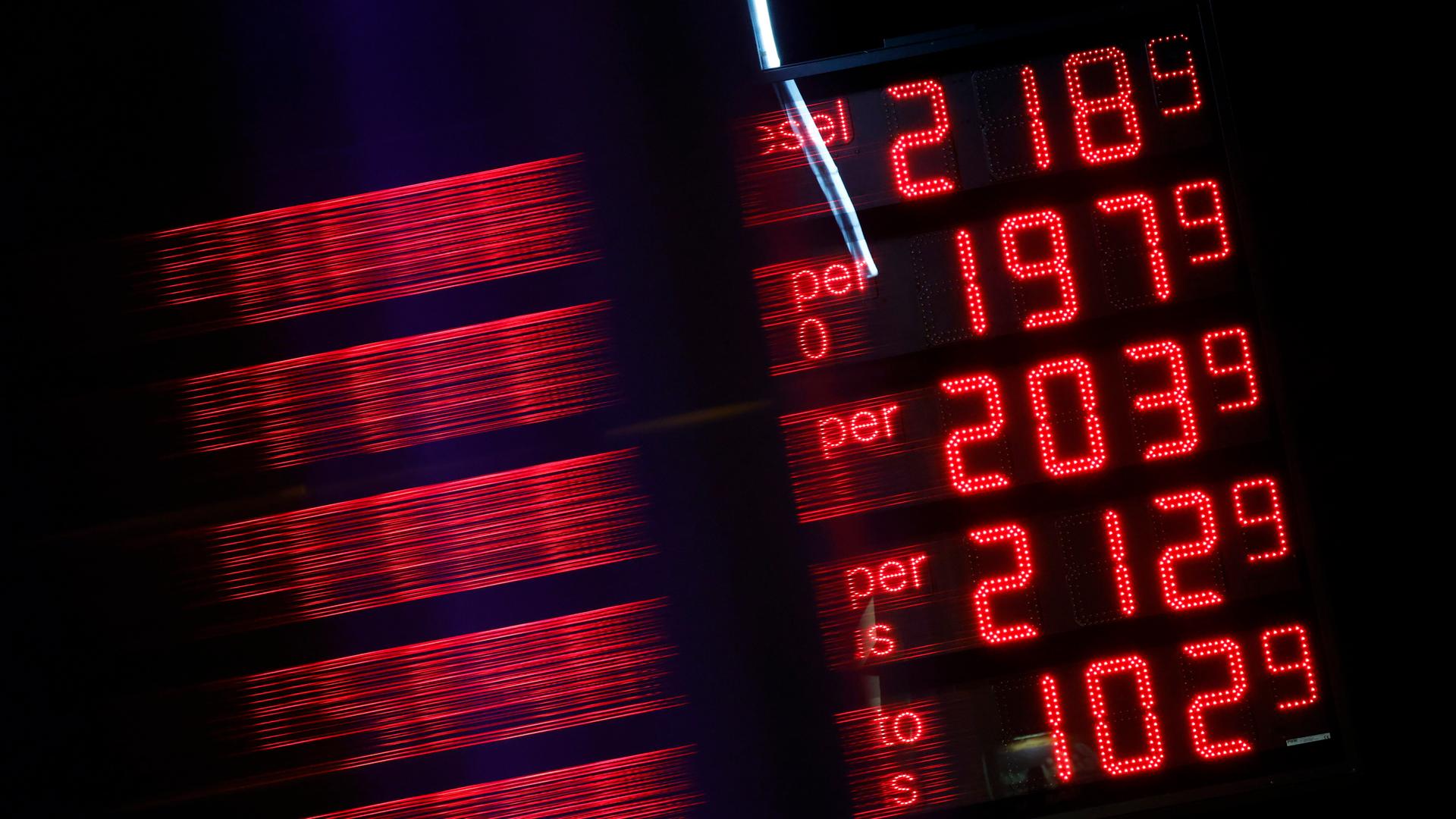 Spritpreise leuchten rot auf einer schwarzen Anzeigetafel einer Tankstelle