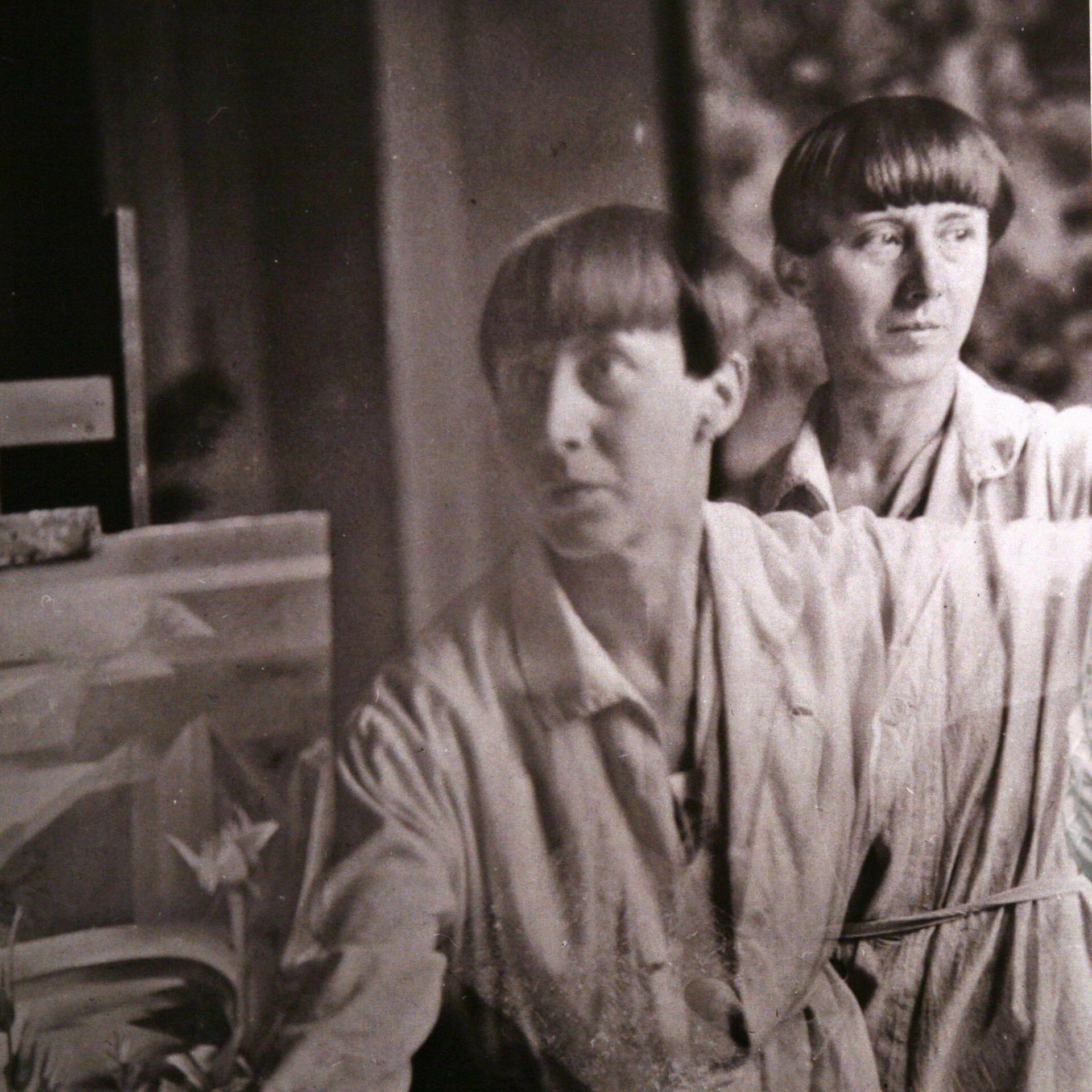 Eine Doppelbelichtung der Dada-Künstlerin Hannah Höch (Fotografie um 1930) betrachtet eine Besucherin in einer Ausstellung ihrer Werke. 