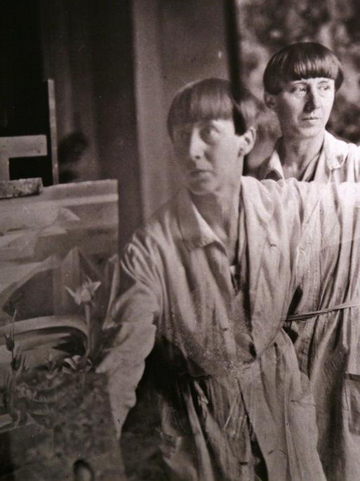 Eine Doppelbelichtung der Dada-Künstlerin Hannah Höch (Fotografie um 1930) betrachtet eine Besucherin in einer Ausstellung ihrer Werke. 