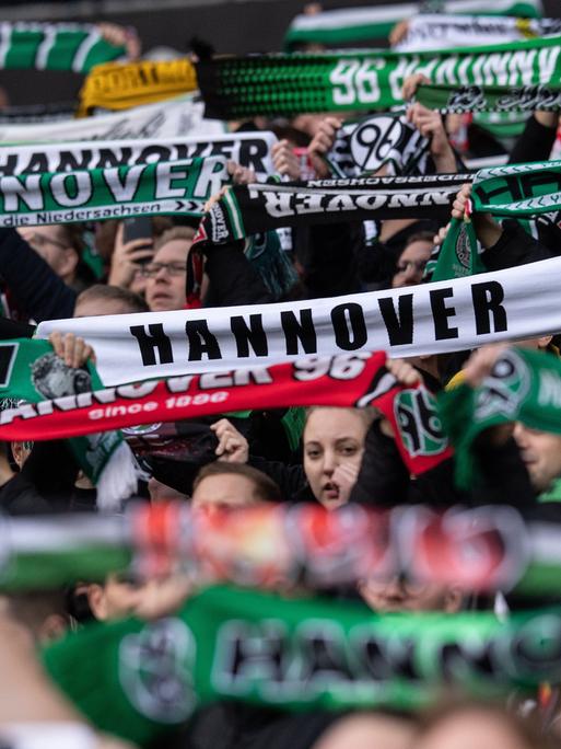 Hannover-Fans stehen im Oktober 2022 mit Schals auf der Tribüne