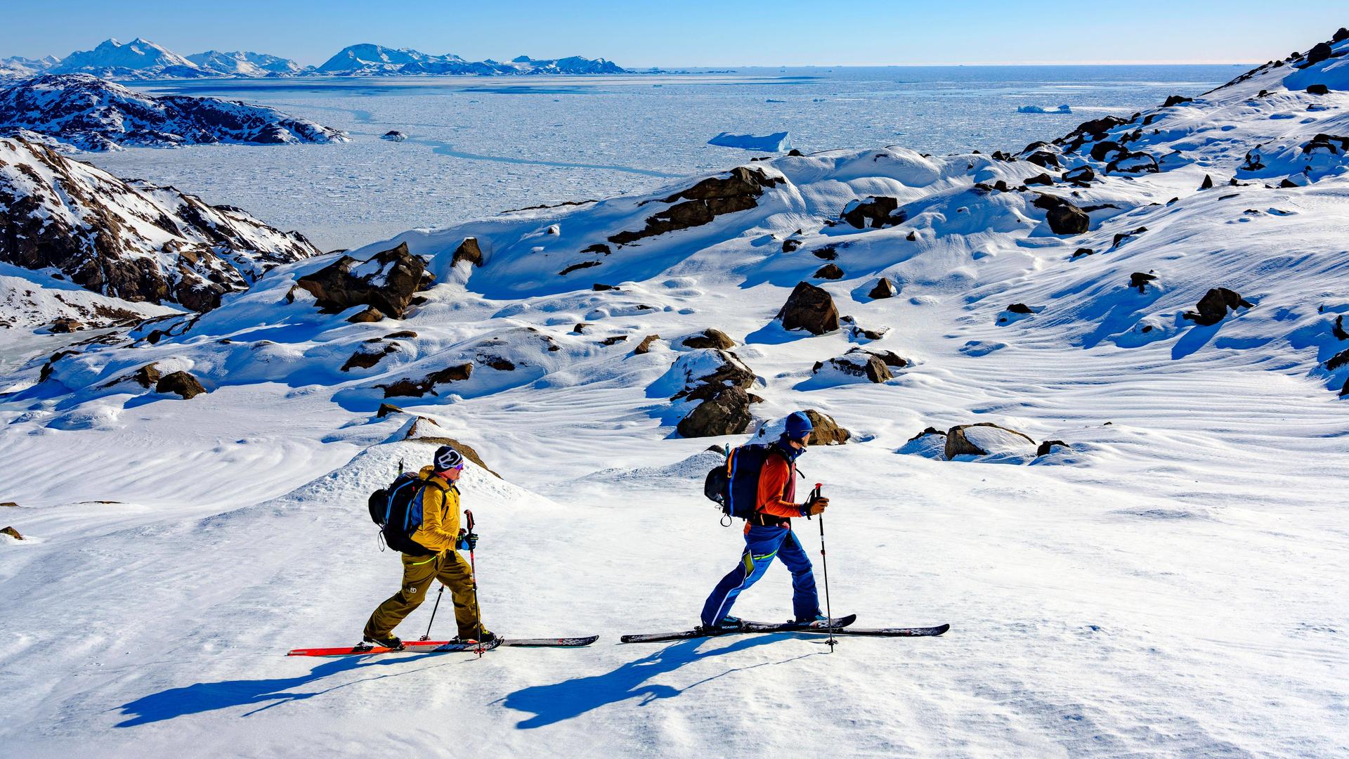 Skibergsteiger auf Skitour in verschneiter Berglandschaft, im Hintergrund ist das Packeis zu sehen. Skibergsteiger auf Skitour in verschneiter Berglandschaft, im Hintergrund ist das Packeis zu sehen.